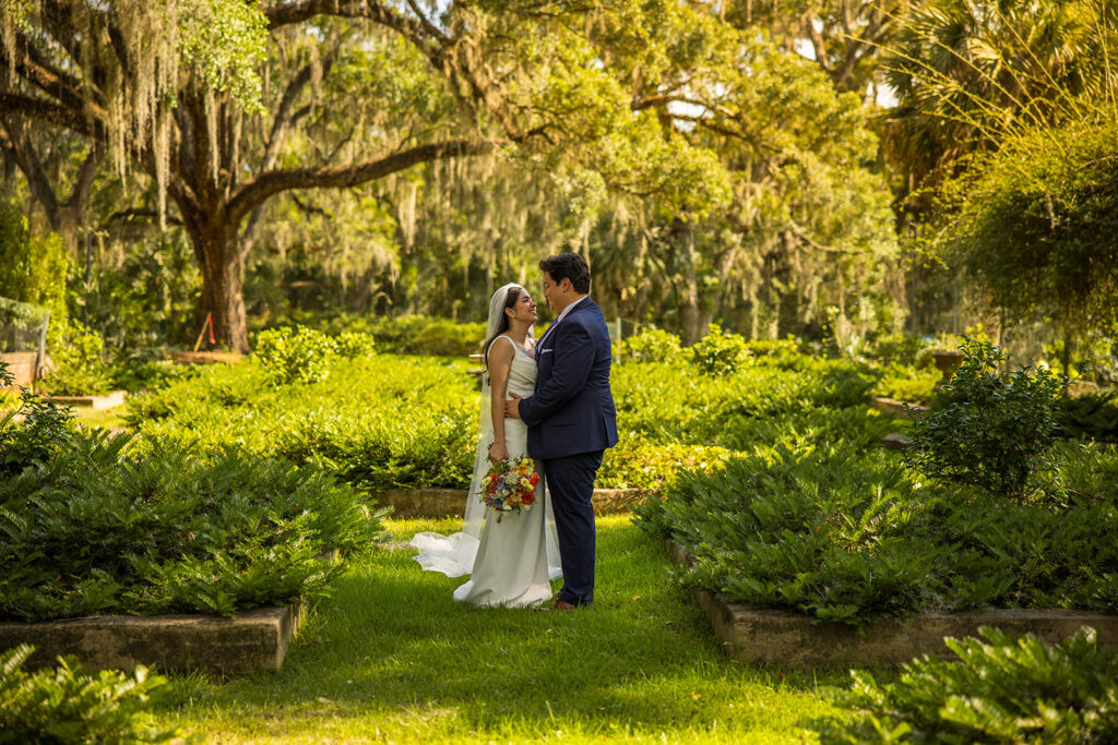 dreamy bride and groom surrounded by lush greenery at their Florida Panhandle wedding venue