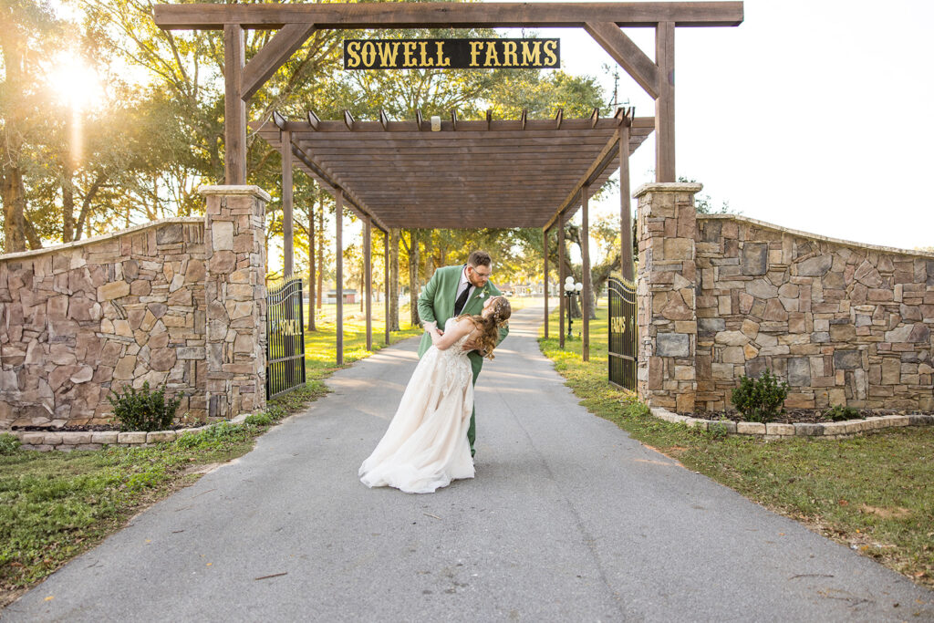 bride and groom dip kiss under the sowell farms sign