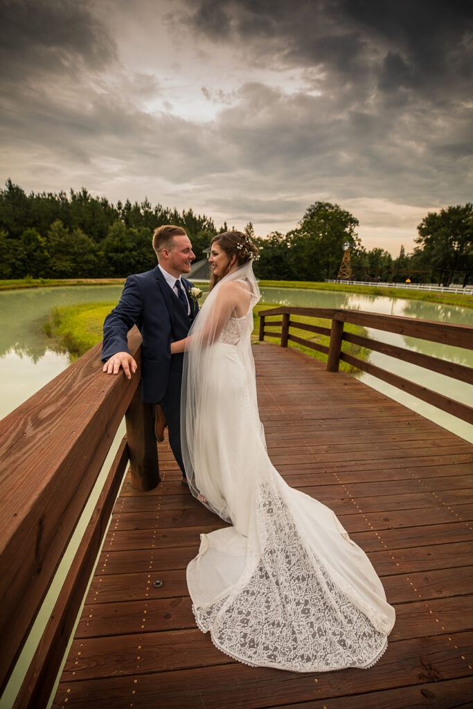 bride and groom posing at the pond at Sowell Farms in Milton, FL