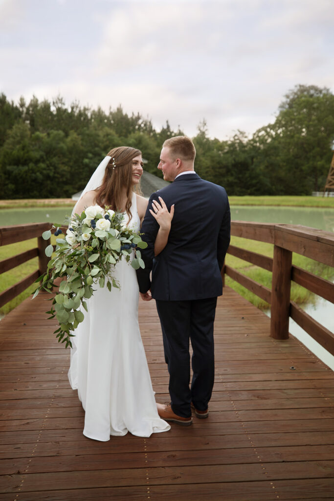 bride and groom posing at the pond at Sowell Farms in Milton, FL