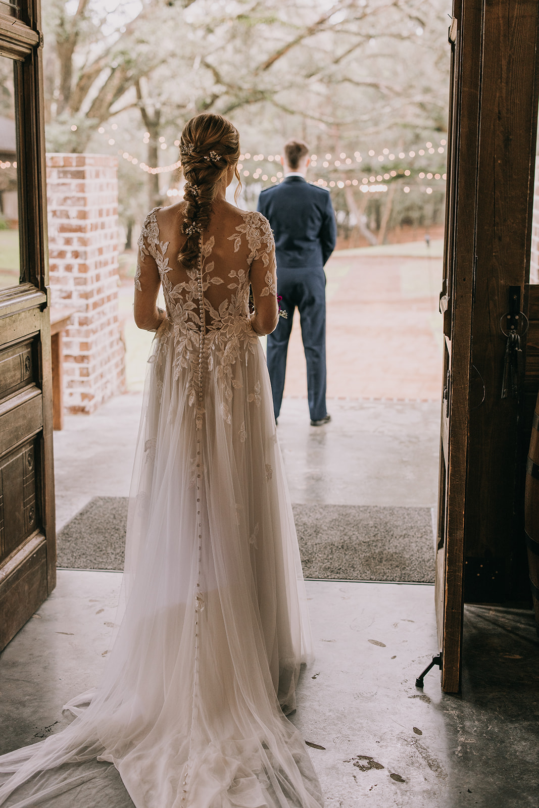 A bride in her white dress approaches her groom from behind before their first look on their wedding day in Pensacola, Florida