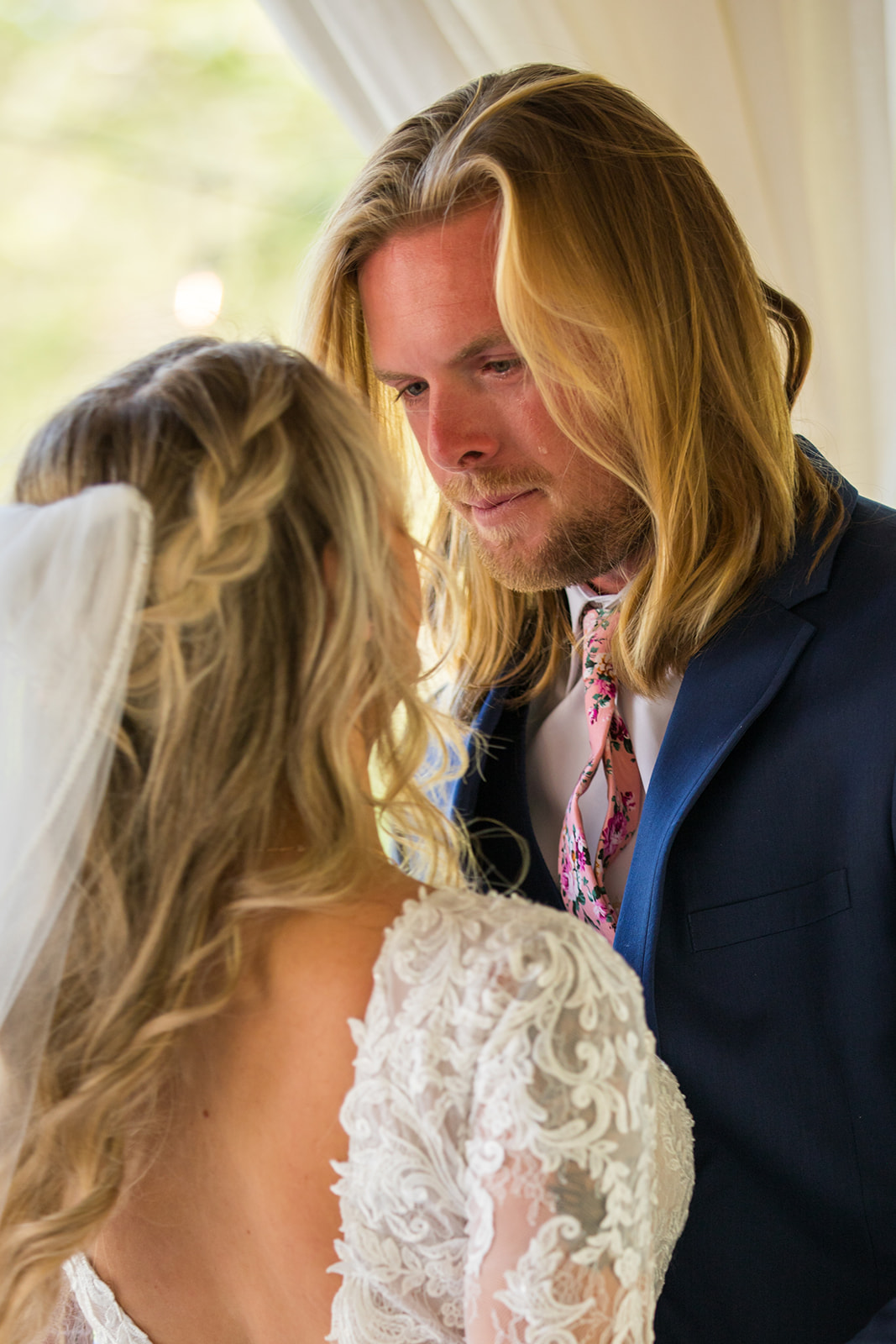 A single tear streams down groom's face as he embraces his bride after their first look.