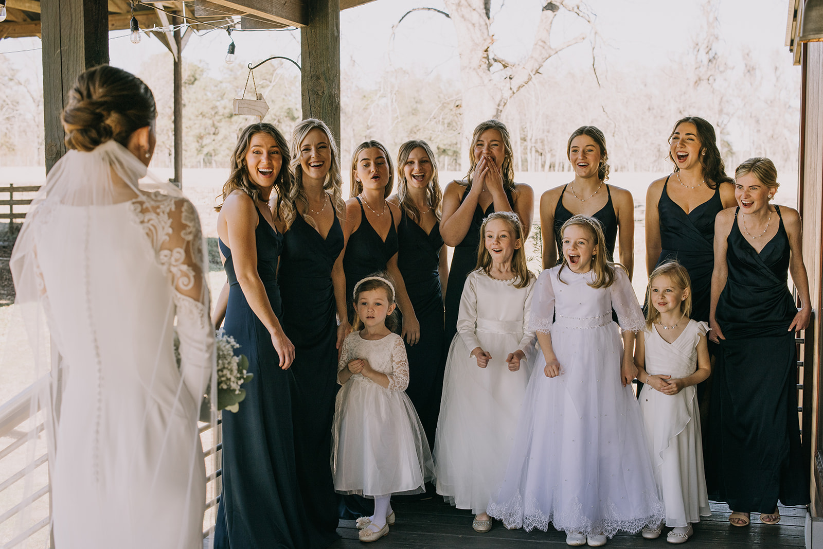 Bridesmaids and flower girls react to seeing the bride in her white wedding dress at Woodberry in Havana, Florida. 